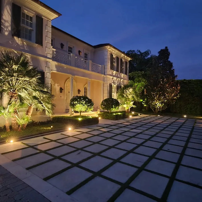 Lighting installation team wiring and placing fixtures during a Miami landscape project