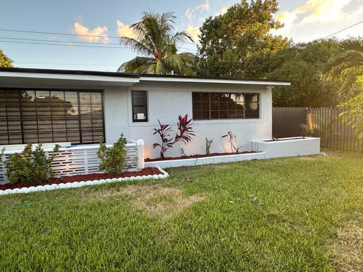 Professional sod installers laying new turf in a residential Miami yard