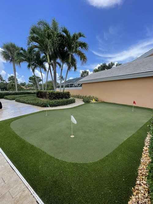 Putting green installed near pool area to create a fun and functional backyard in Miami